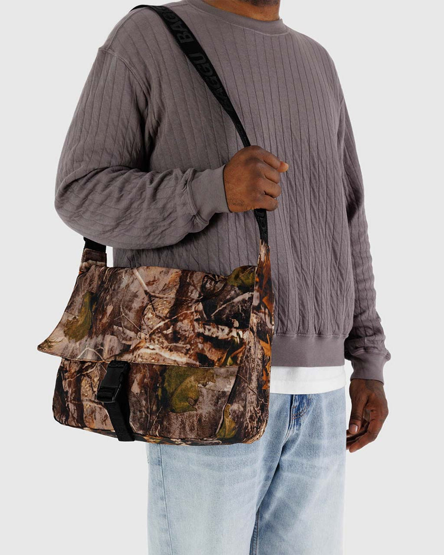 model holding photo forest large messenger bag with black strap and closure 