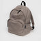 large taupe nylon backpack with two front zipper compartments and drink holder on the side