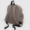 back view of large taupe nylon backpack with two front zipper compartments and drink holder on the side