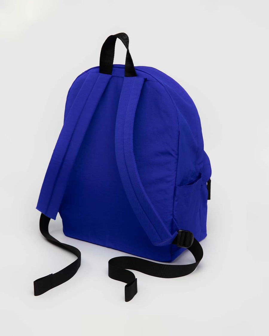 back view of large bright blue nylon backpack with two front zipper compartments and drink holder on the side