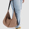 model holding light brown large nylon crescent bag