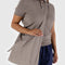 model wearing large taupe nylon sling bag with adjustable strap