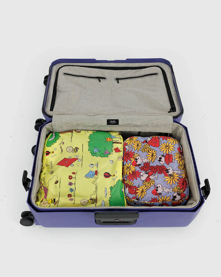 set of 2 peanuts large packing cubes. periwinkle joe cool floral and yellow charlie brown flying a kite in a suitcase