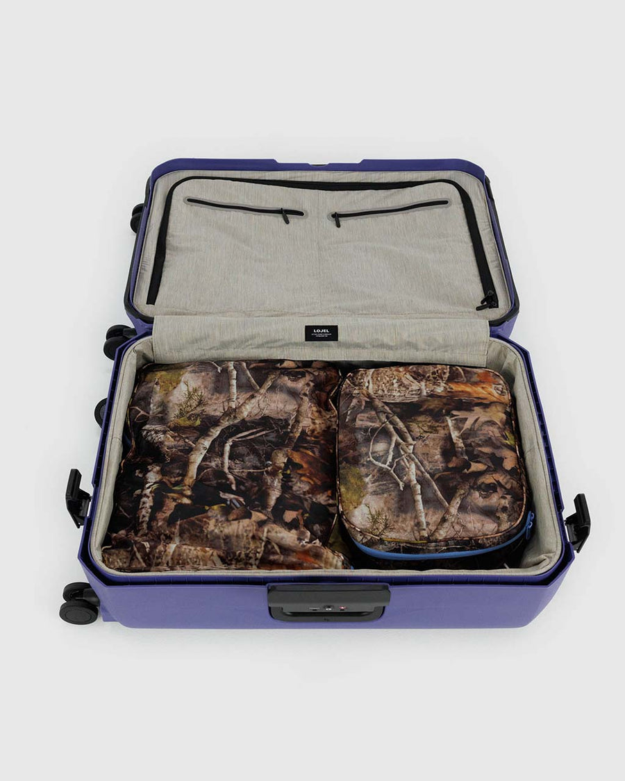 set of two large packing cube set with realistic forest print and cornflower trim zipper in a suitcase