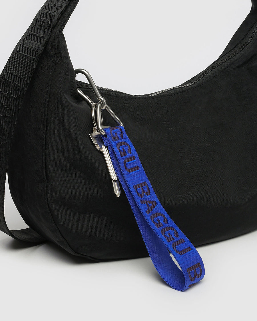 cobalt keychain with dark blue 'baggu' font attached to a purse