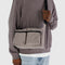 model wearing taupe medium nylon cargo crossbody with black trim and two large front pockets