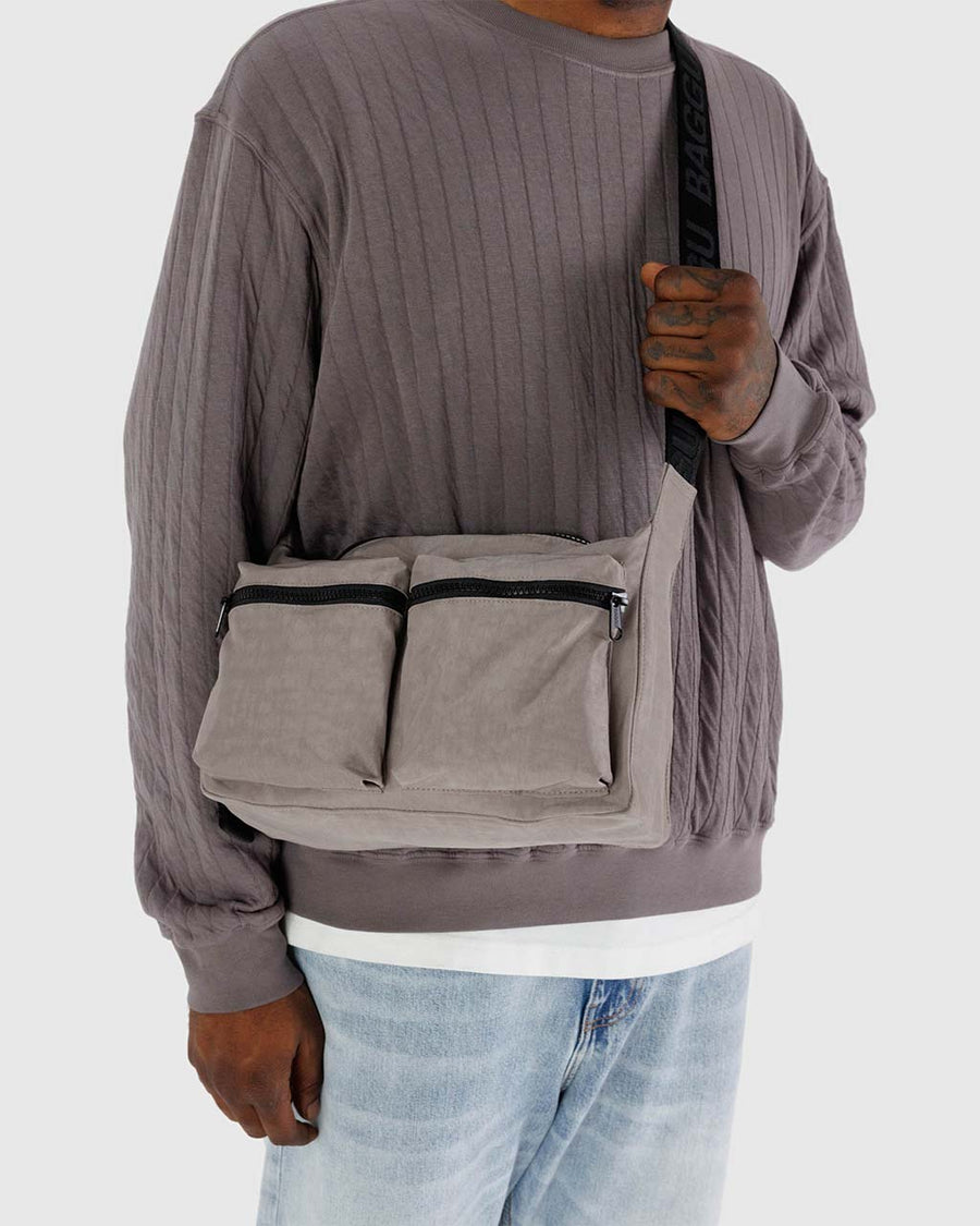 model wearing taupe medium nylon cargo crossbody with black trim and two large front pockets