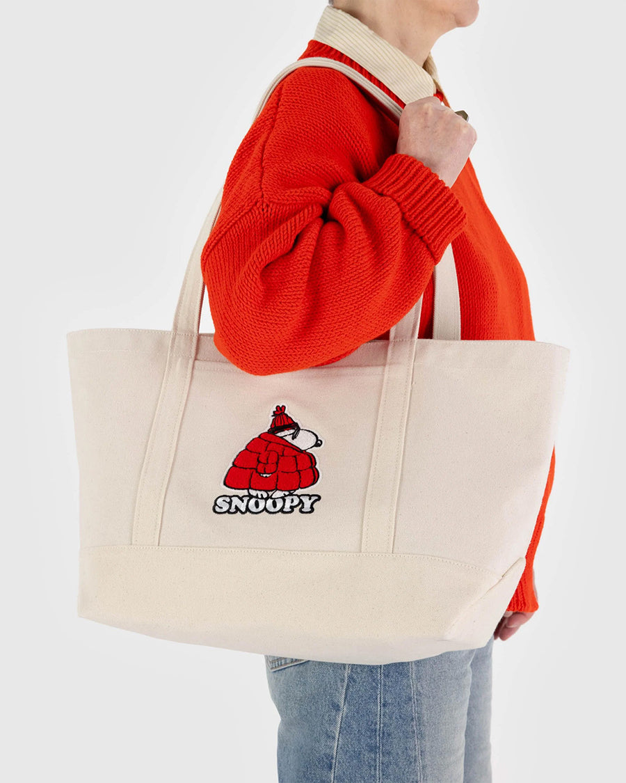 modle carrying medium heavyweight canvas tote with snoopy in a red puffer jacket and embroidered snoopy'