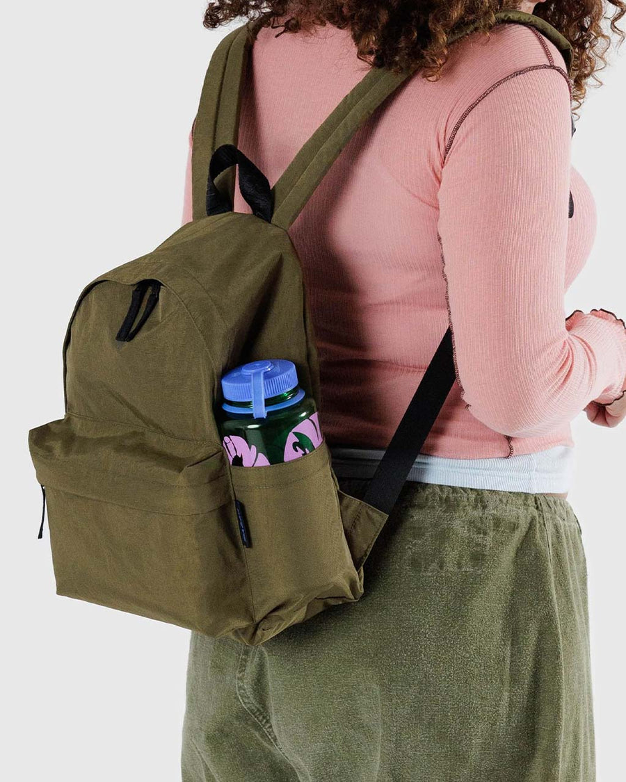 model carrying dark green medium size nylon backpack