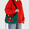 model carrying dark green medium crescent bag with snoopy and woodstock in a red puffer coat and hat