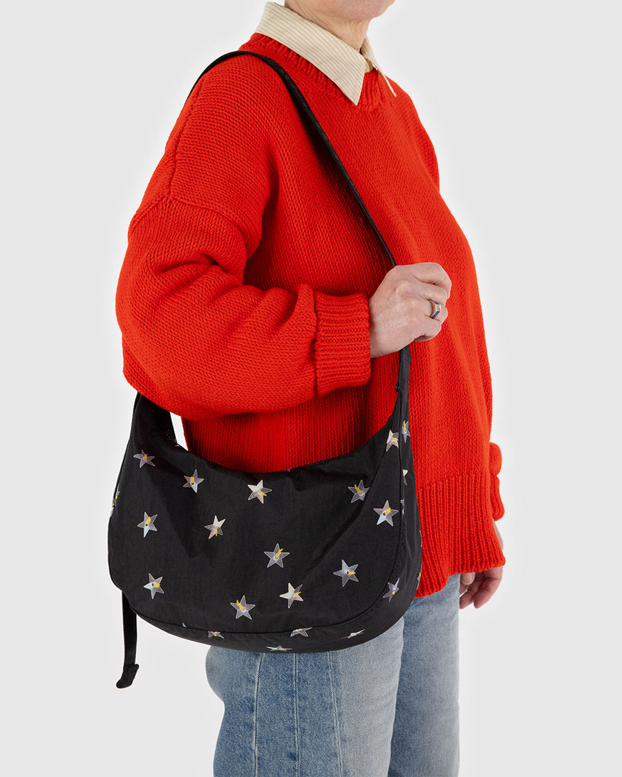 model carrying black medium crescent bag with metallic star print