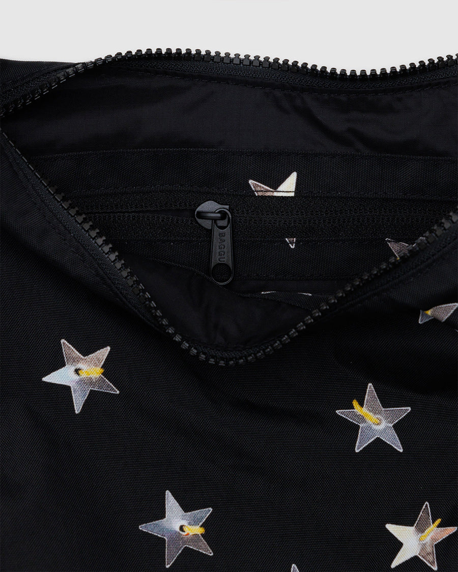 up close of zipper of black medium crescent bag with metallic star print