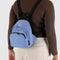 model wearing cornflower mini nylon with larger zipper compartment and small zippered front compartment