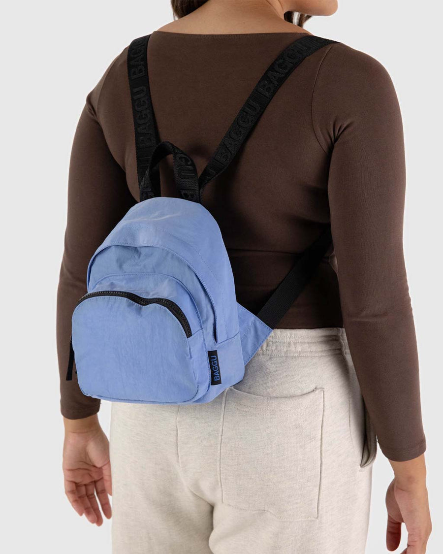 model wearing cornflower mini nylon with larger zipper compartment and small zippered front compartment