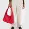 model holding candy apple red  nylon shoulder bag