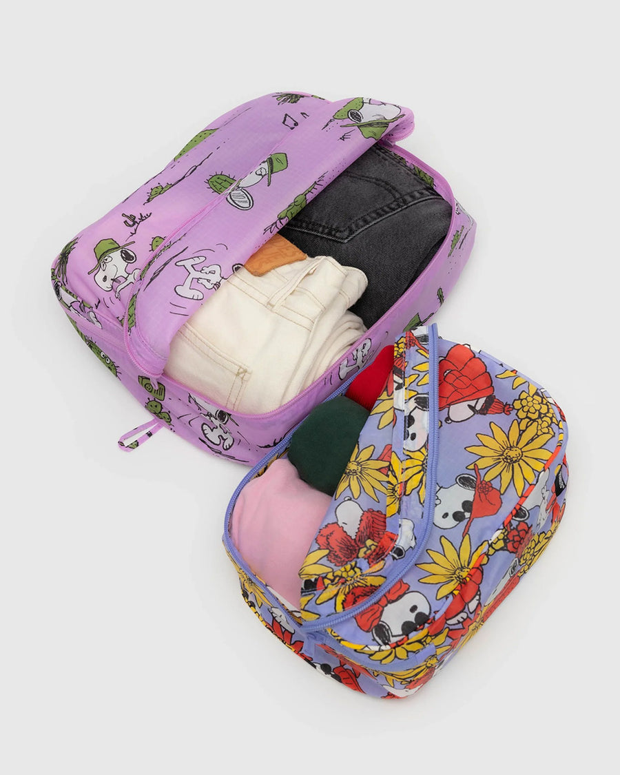 set of two packing cube sets: periwinkle snoopy floral and pink spike desert print with items inside