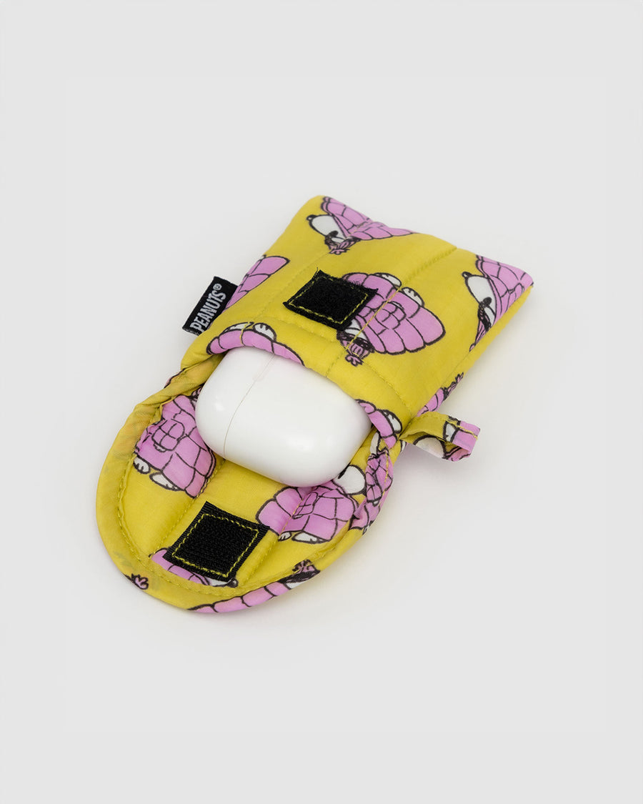 yellow earbud case with snoopy in a pink puffer coat with earbuds inside