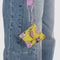 model carrying yellow earbud case with snoopy in a pink puffer coat on a lanyard