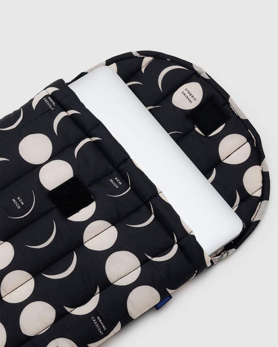 black 16 inch puffy laptop sleeve with white moon phase print with a laptop sticking out