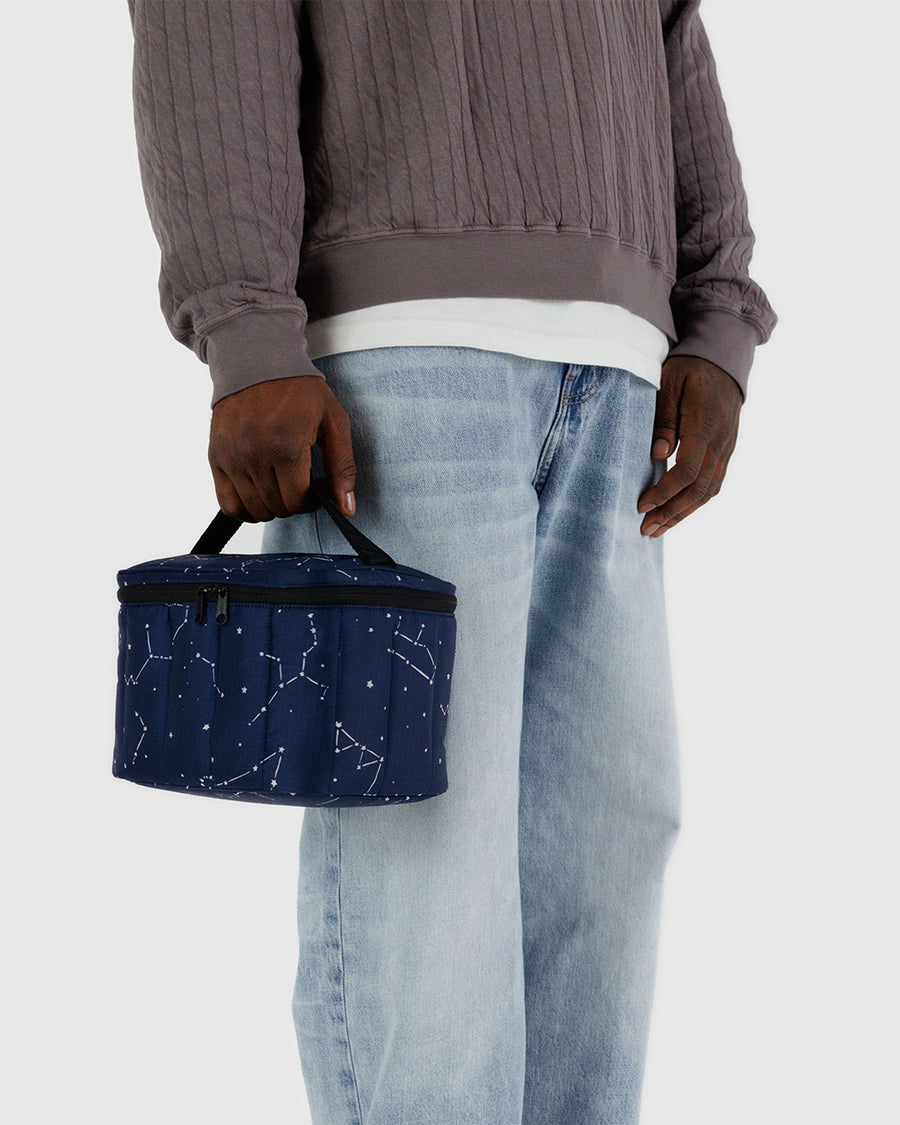 model holding navy puffy lunch bag with white constellation print