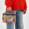 model holding puffy lunch bag with joe cool and red and yellow floral print