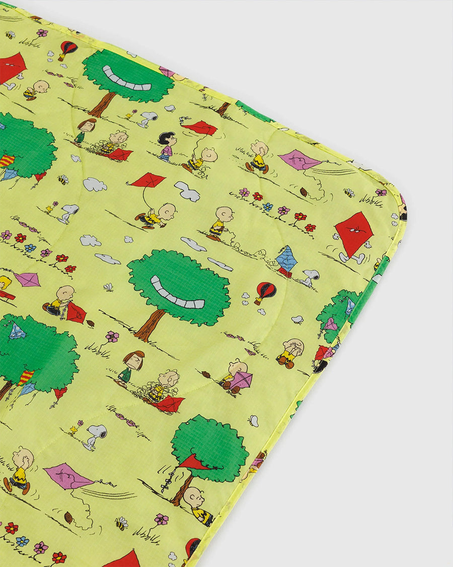 up close of ellow puffy picnic blanket with charlie brown and friends flying kites