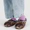 model wearing puffer slippers with realistic forest print and periwinkle trim