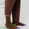 model wearing brown ribbed crew socks with periwinkle, green and purple accents