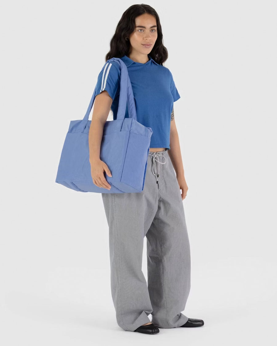 model carrying cornflower small cloud carry on bag