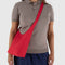 model wearing candy apple small nylon sling bag