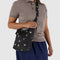 model carrying black small sling bag with metallic star print