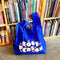 royal blue standard baggu with white 'book person' and pink shapes across the front in a library