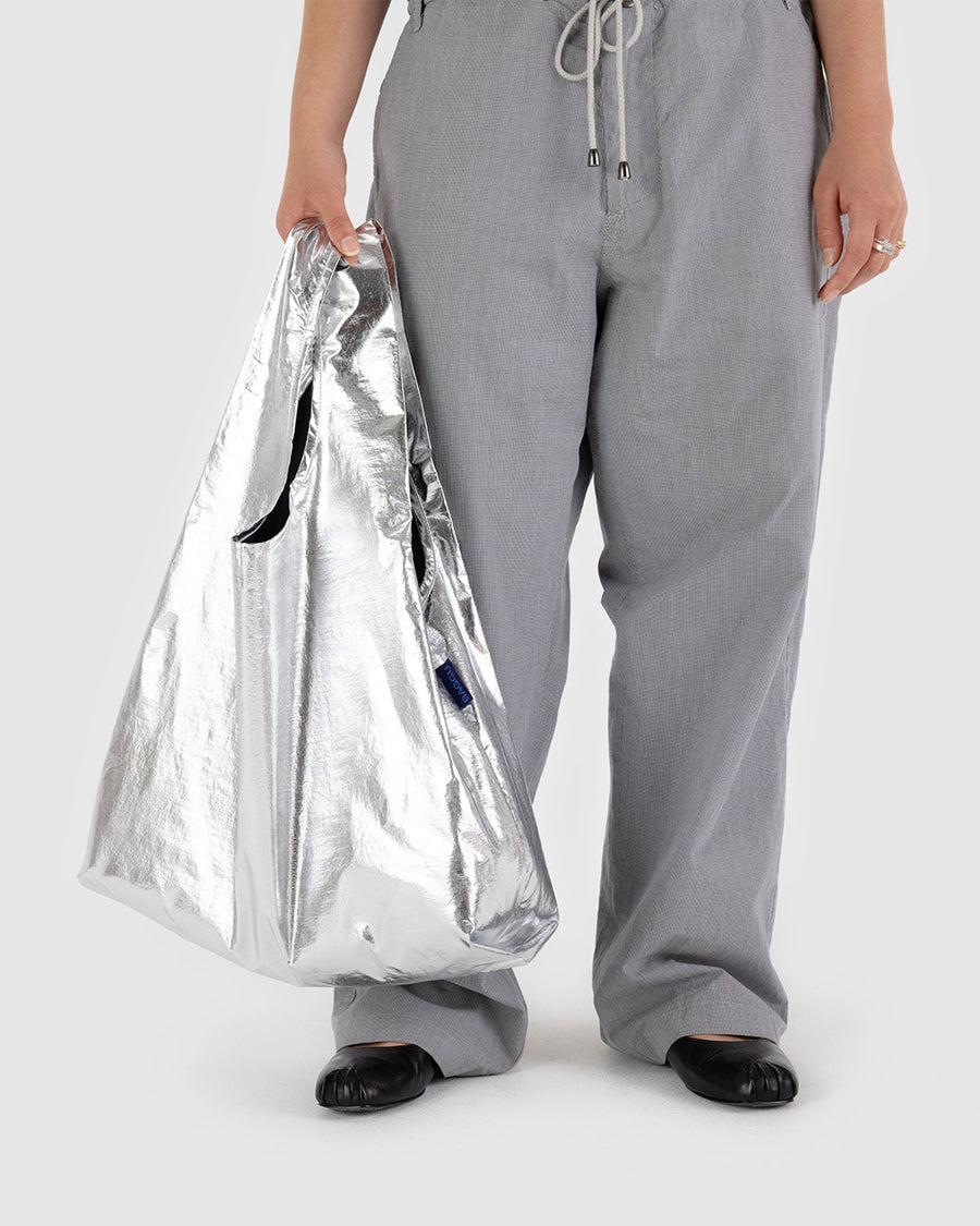 model holding metallic silver standard baggu