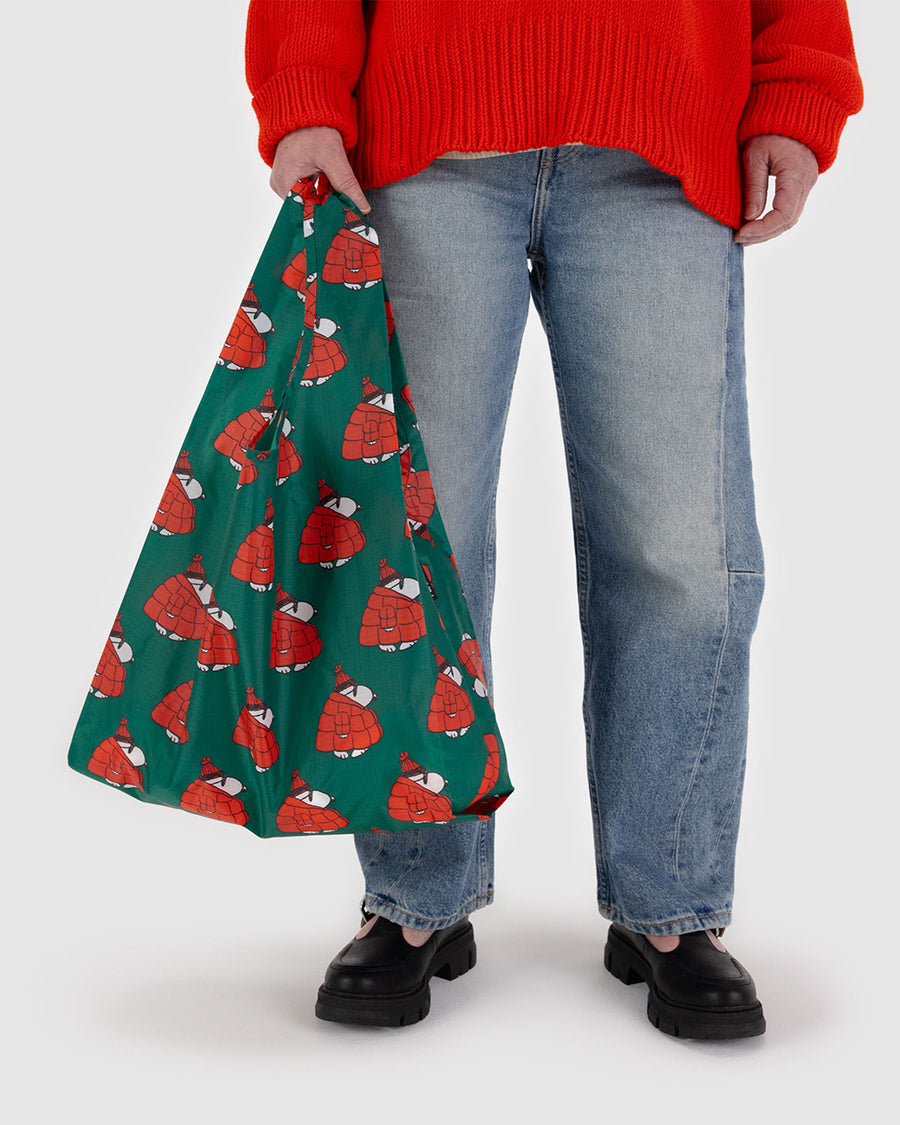 model holding green standard baggu with snoopy in a red puffer coat