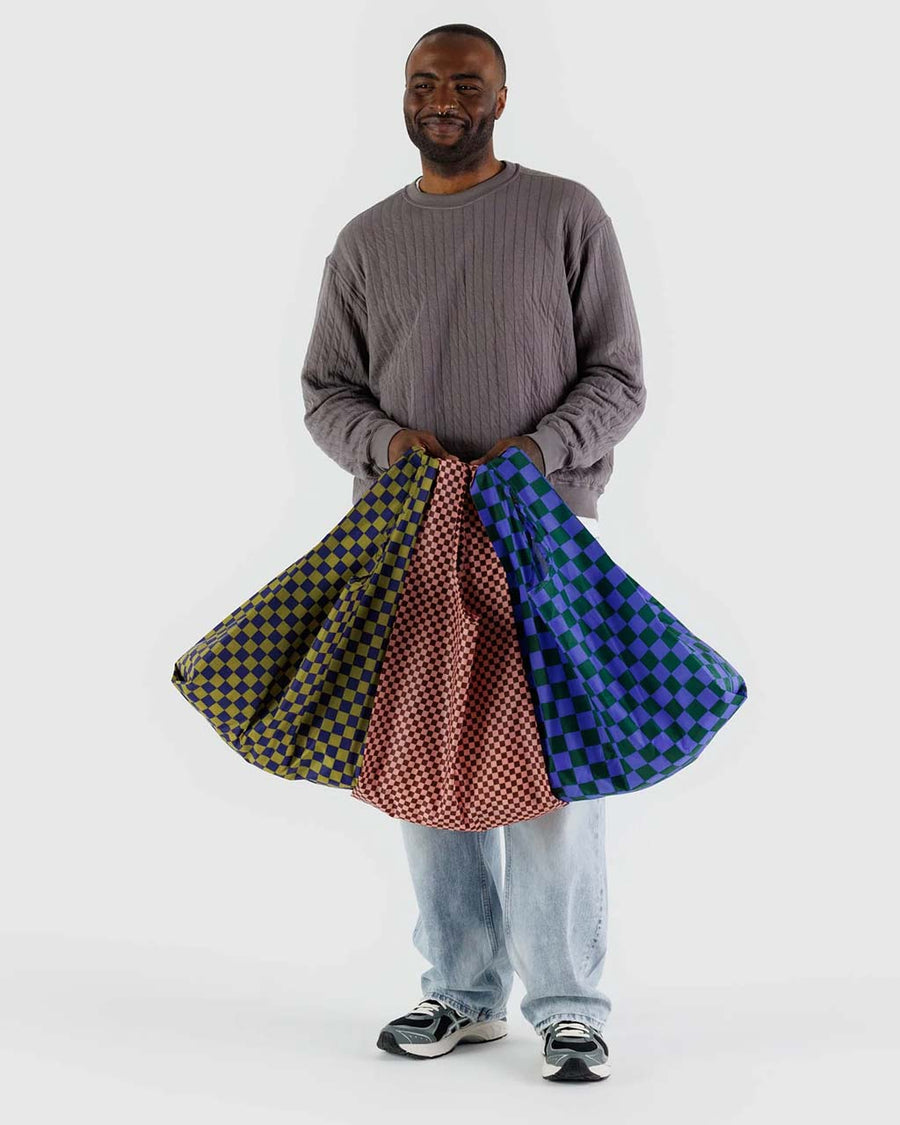 model holding three standard baggus in various checker colors