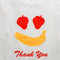 up close of side view of white standard baggu with fruit smiley (strawberry eyes and banana smile) with red 'thank you'