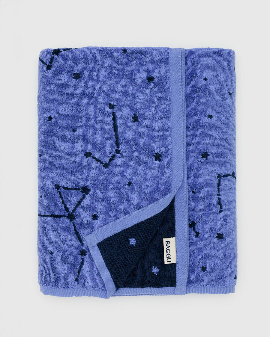 folded reversible bath towel with periwinkle constellation and dark blue constellation