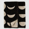 folded reversible bath towel with black and cream moon phase print