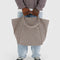 model holding taupe travel cloud bag