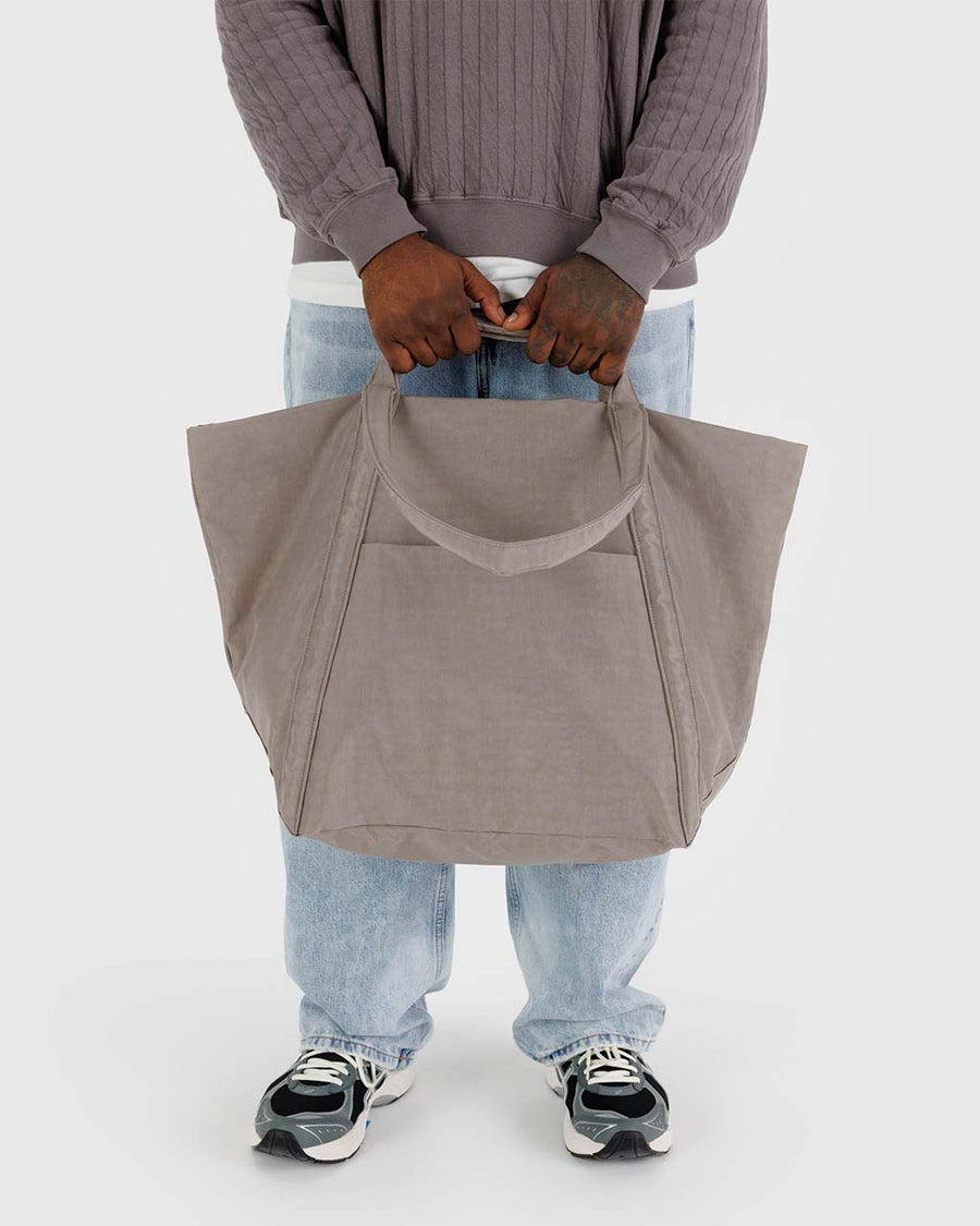 model holding taupe travel cloud bag