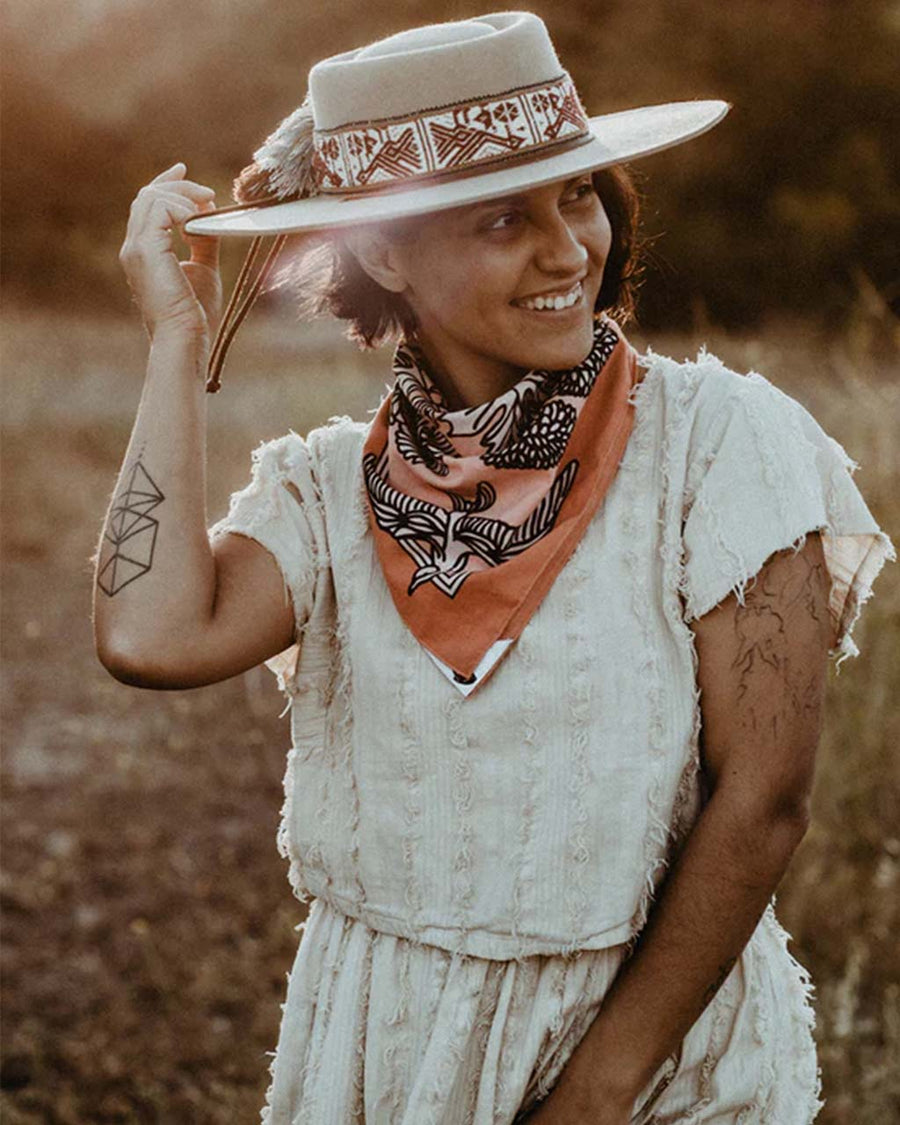 model wearing pink and orange square bandana with bird and floral print