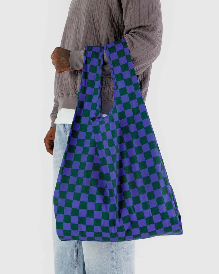 model holding green and dark blue checkered big baggu