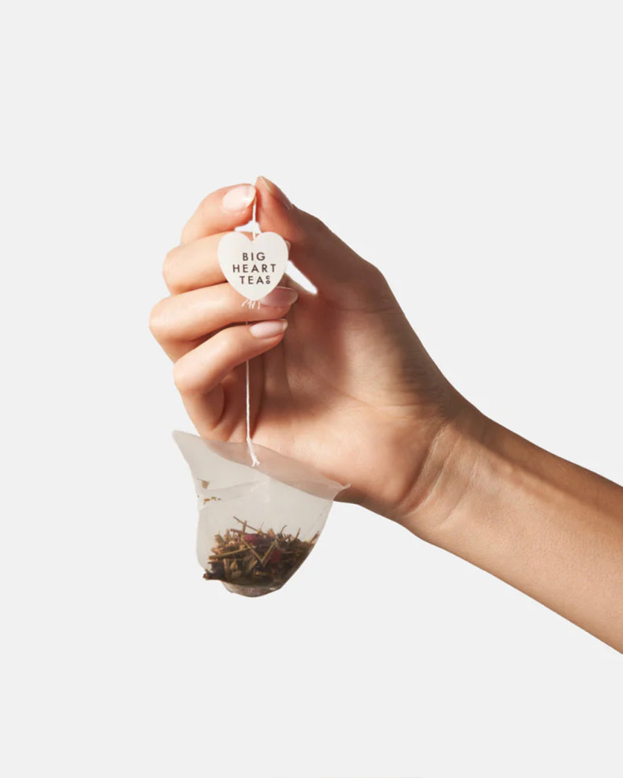 model holding pink hibiscus tea bag