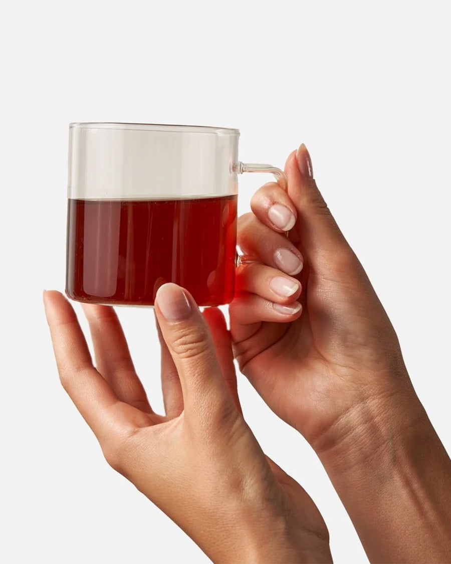 model holding cup of winter chai tea in a glass cup