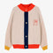 cream knit cardigan with yellow sleeve cuffs, coral trim and navy button front with embroidered couple on bust