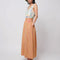model wearing pink and yellow gingham maxi skirt with smocked waist and side pockets