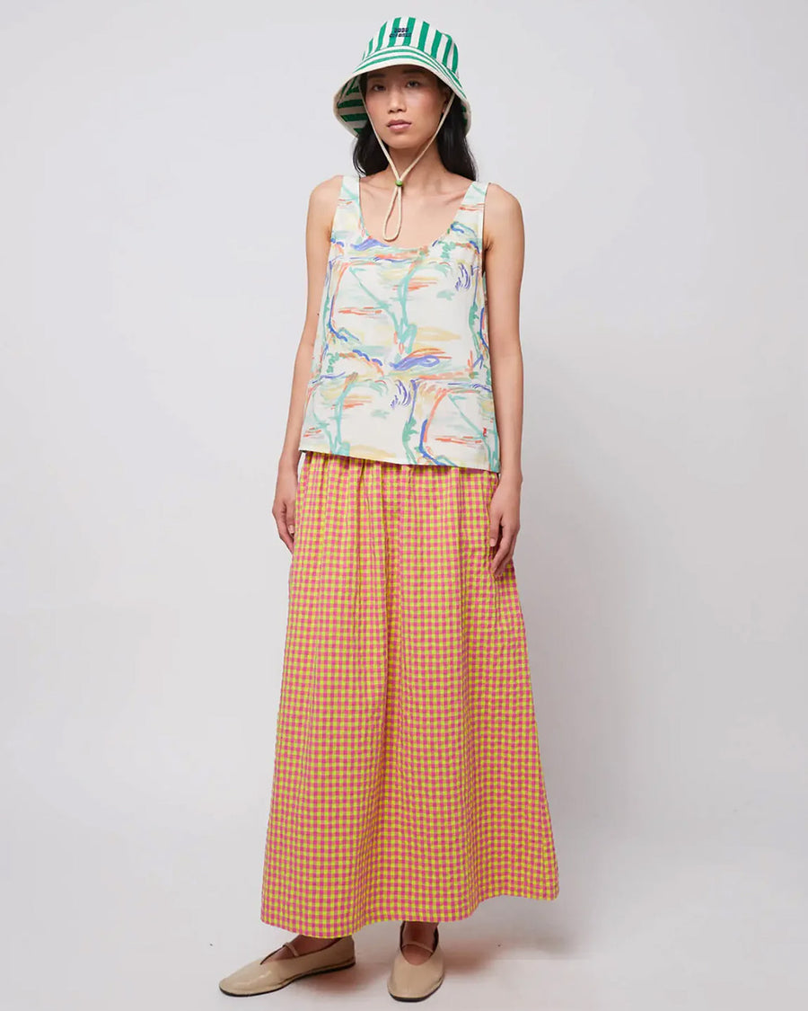 model wearing pink and yellow gingham maxi skirt with smocked waist and side pockets