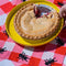 pink and white plaid placemat with black ant border with a pie on it