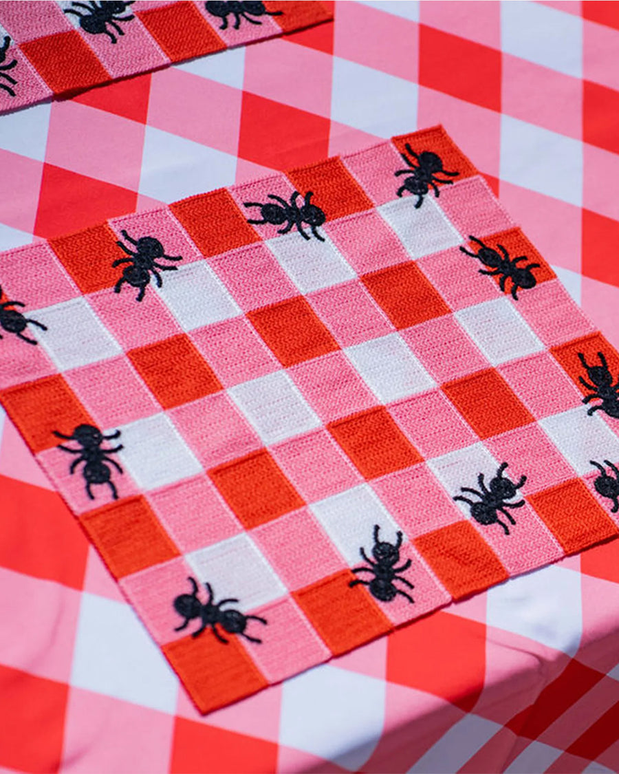 pink and white plaid placemat with black ant border