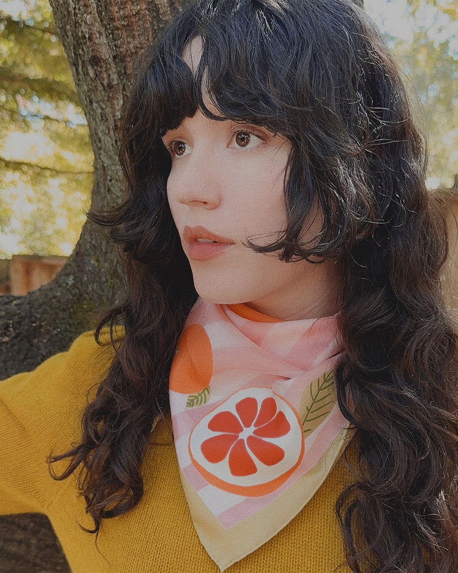 model wearing pink and white stripe bandana with orange print